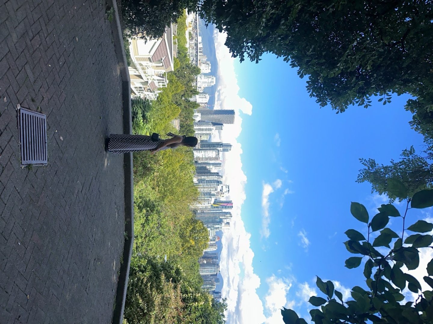 Person standing and overlooking a city skyline surrounded by greenery, symbolizing healing, perspective, and creating new memories in meaningful places